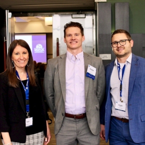 3 Members standing and posing for photo outside of a session room